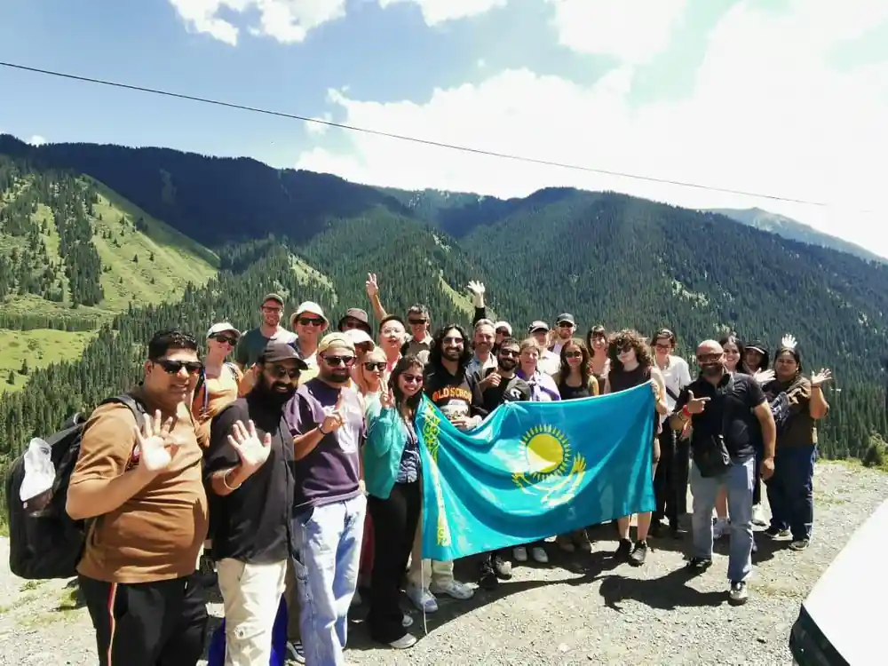 Group of people holding Kazakhstan flag in mountain valley