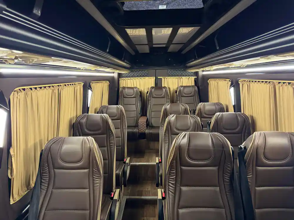 Interior of luxury coach with cream curtains and dark leather seats