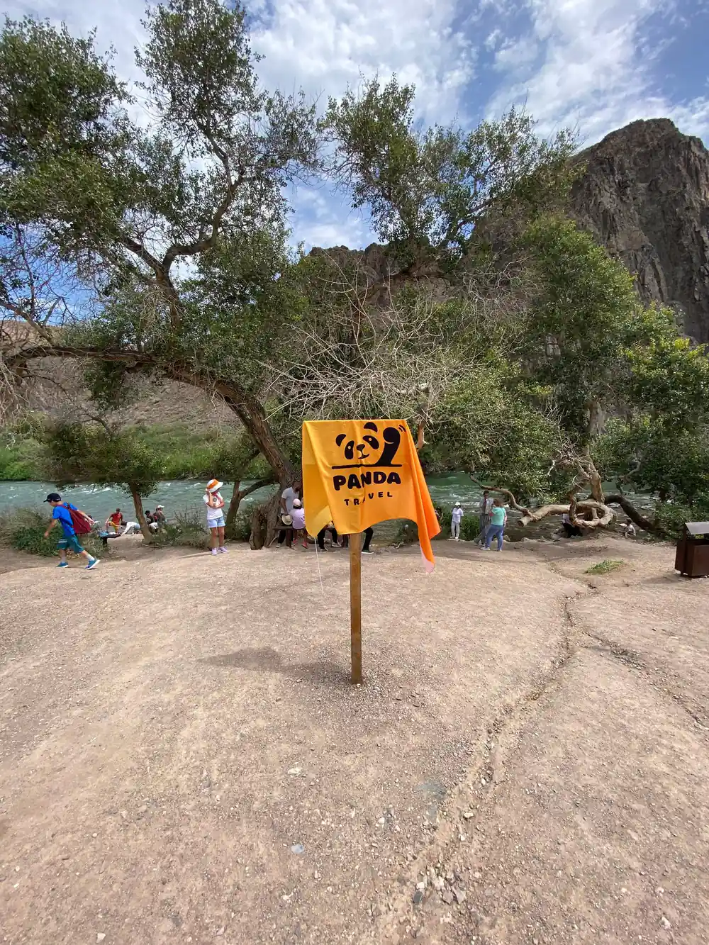 Panda Trail yellow sign at campground with rock formation and people