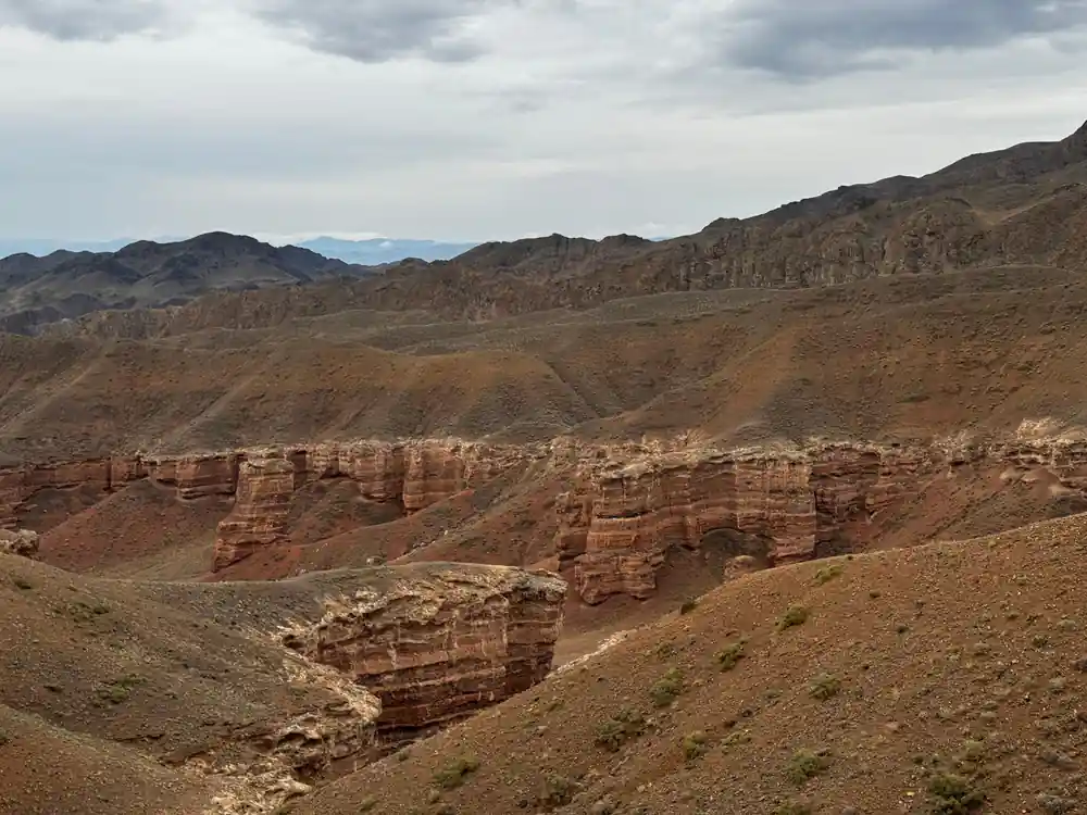 Red sandstone formations and gullies in arid mountain valley