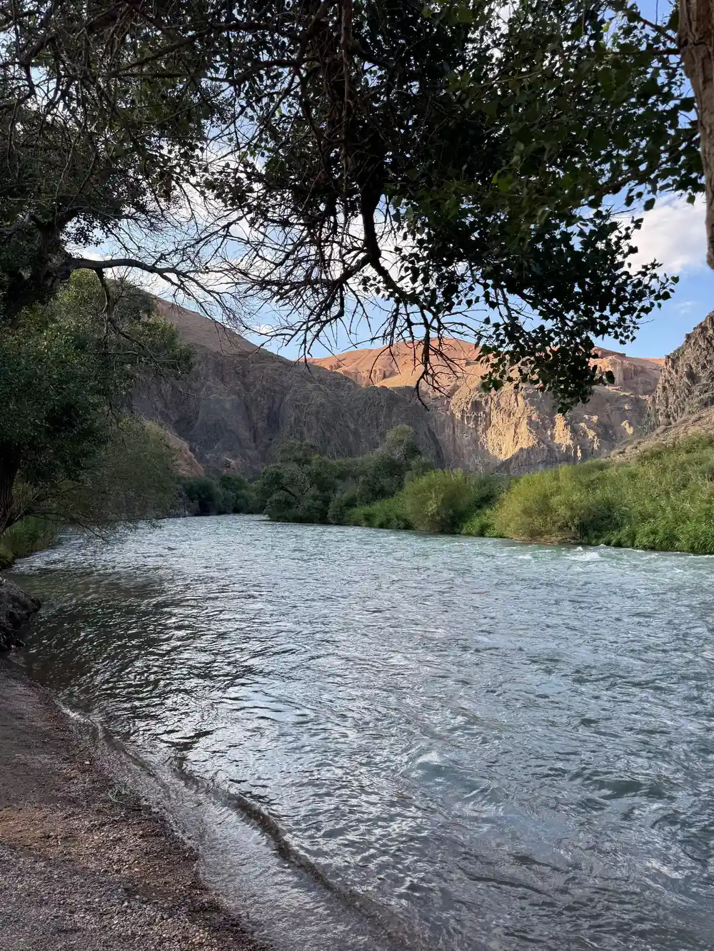 River flowing through valley with rocky cliffs and trees