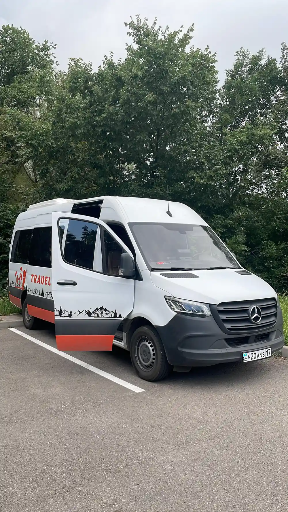 White Mercedes minibus with Panda Travel branding parked